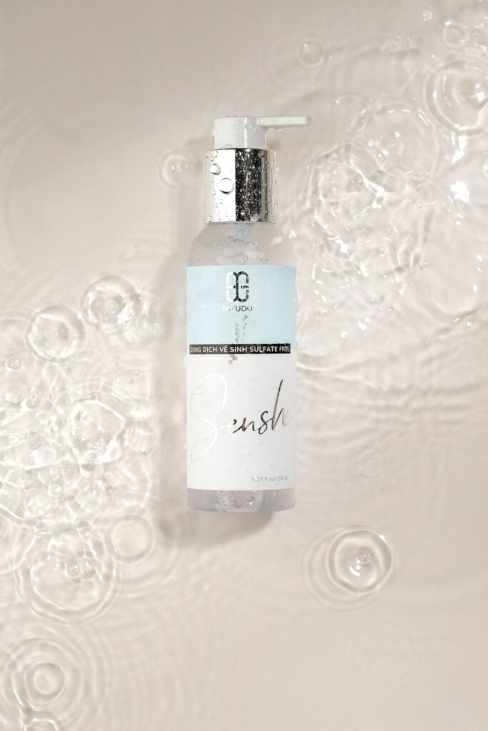 Botol skincare generik dengan air sebagai elemen editorial